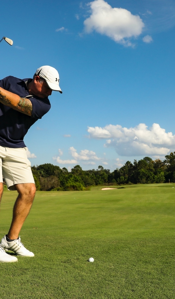 Мужчина занимается гольфом на поле