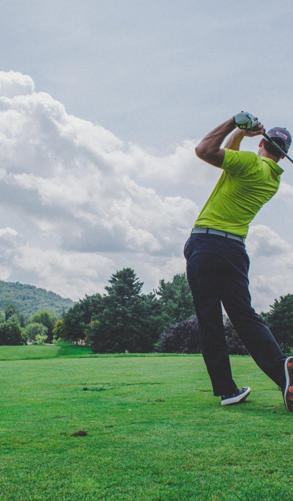 Мужчина играет в гольф на поле