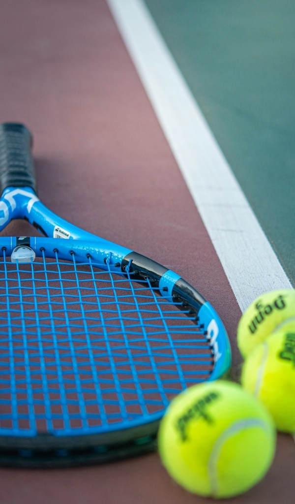 Ракетка и теннисные  мячи на корте