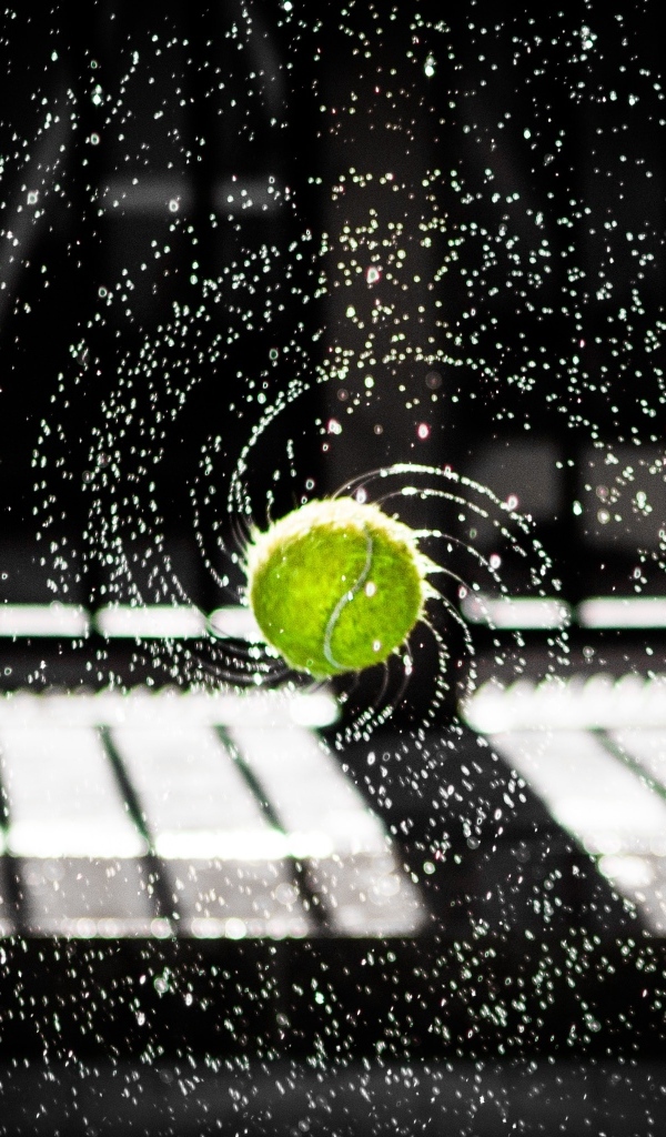 Теннисный мяч в брызгах воды