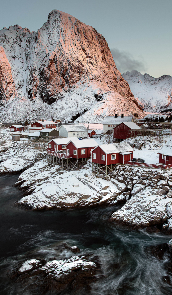 Покрытые снегом дома и гора у воды, Норвегия Лофотенские острова