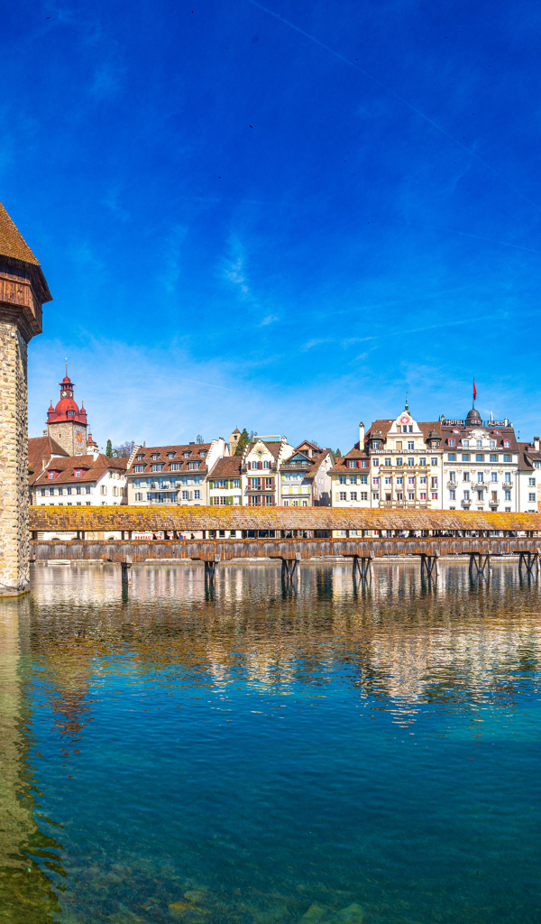 Башня и дома отражаются в воде, город Люцерн. Швейцария