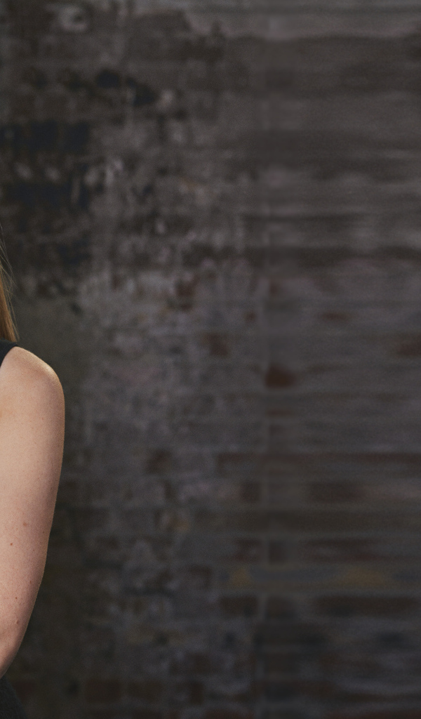 Актриса Аманда Сайфред на фоне кирпичной стены