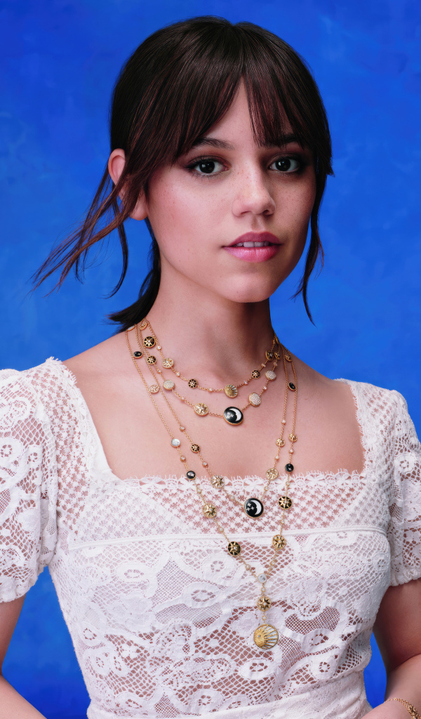 Актриса Дженна Ортега в белом платье на голубом фоне