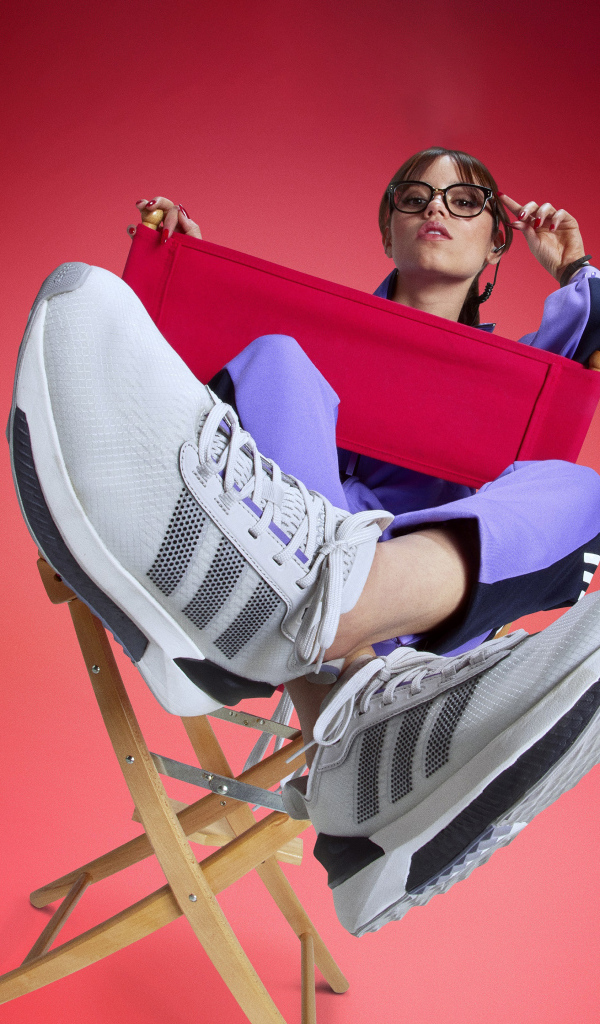 Актриса Дженна Ортега в кроссовках адидас сидит на стуле