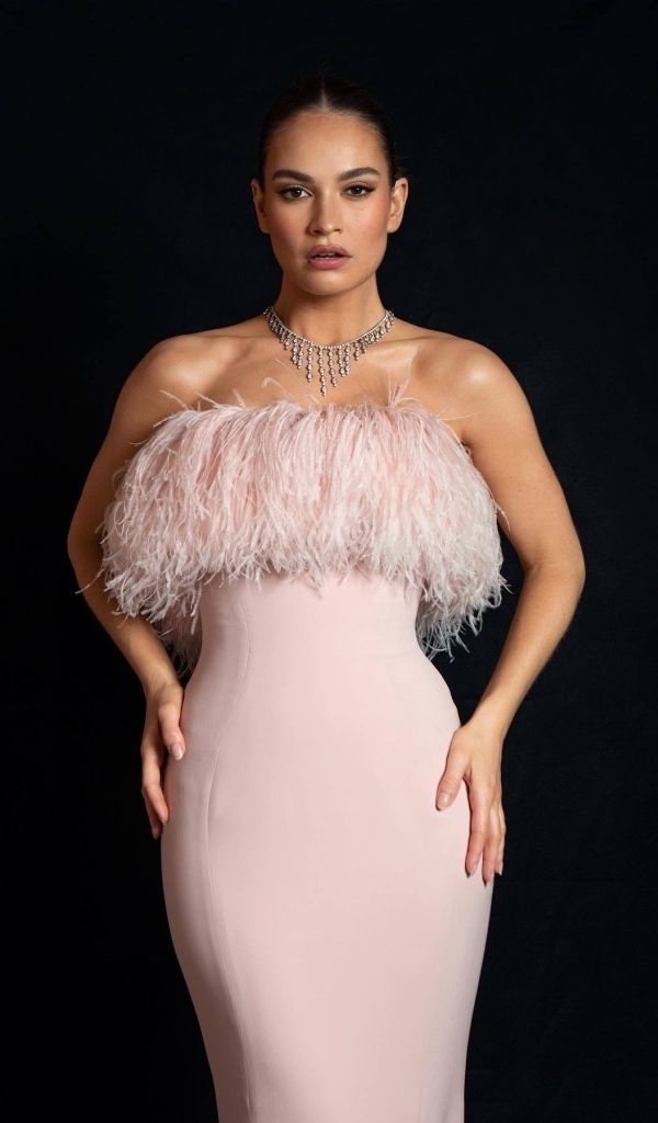 Актриса Лили Джеймс в розовом платье на черном фоне