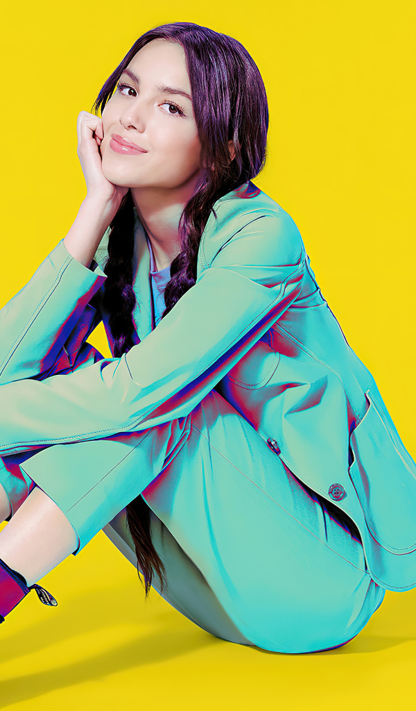 Актриса Оливия Родриго в костюме на желтом фоне