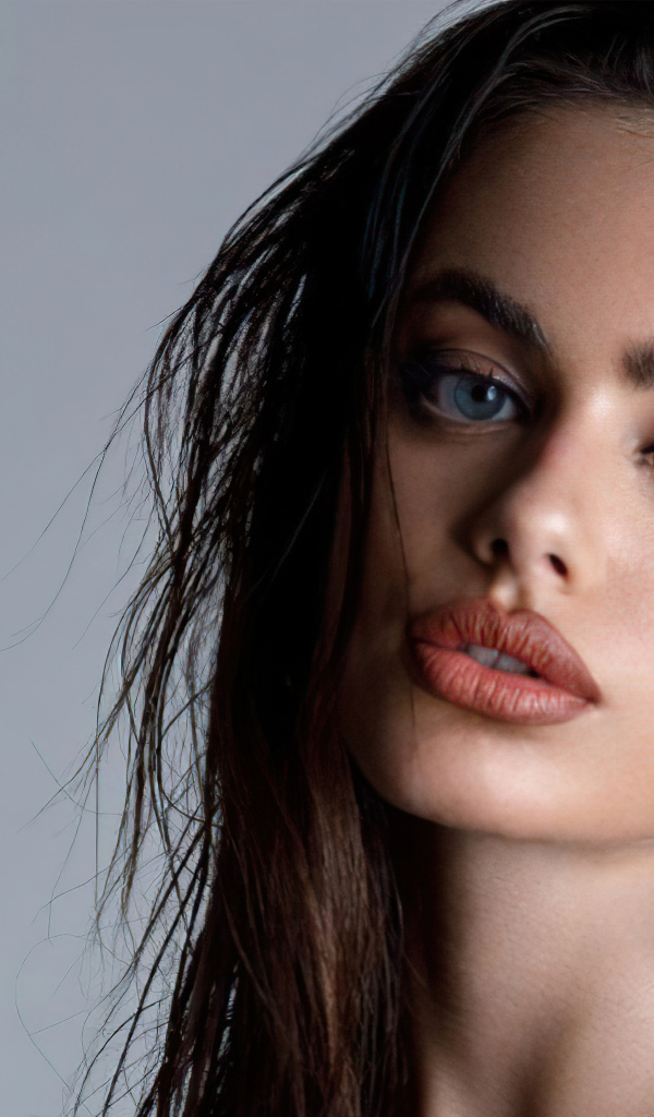 Красивая голубоглазая девушка Яэль Шелбиа на сером фоне