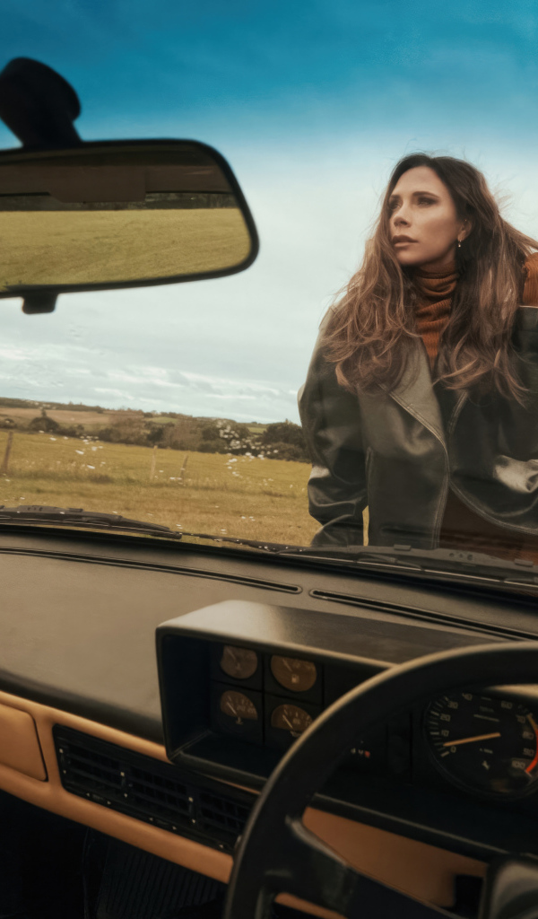 Красивая девушка Виктория Бекхэм сидит на машине