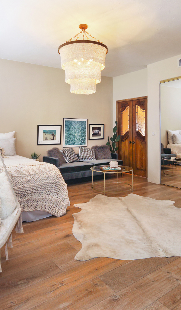 Спальня с белой кроватью и большим зеркалом