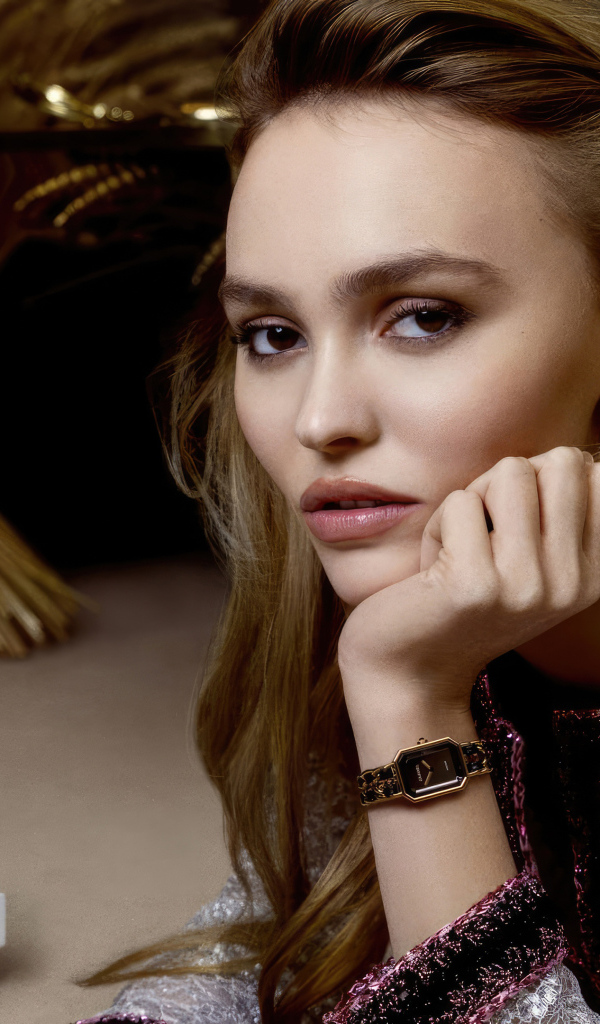 Милая девушка Лили-Роуз Депп сидит за столом