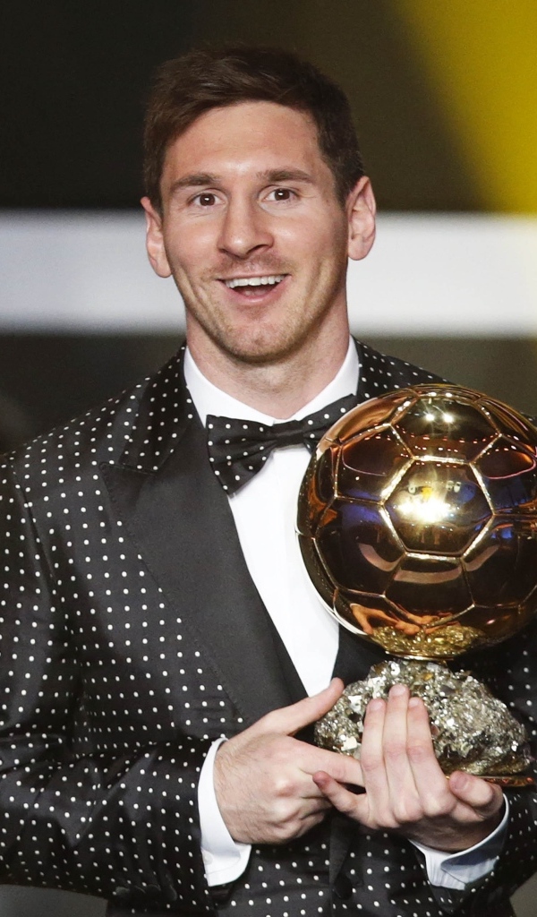 Футболист Лионель Месси с золотым мячом в руках