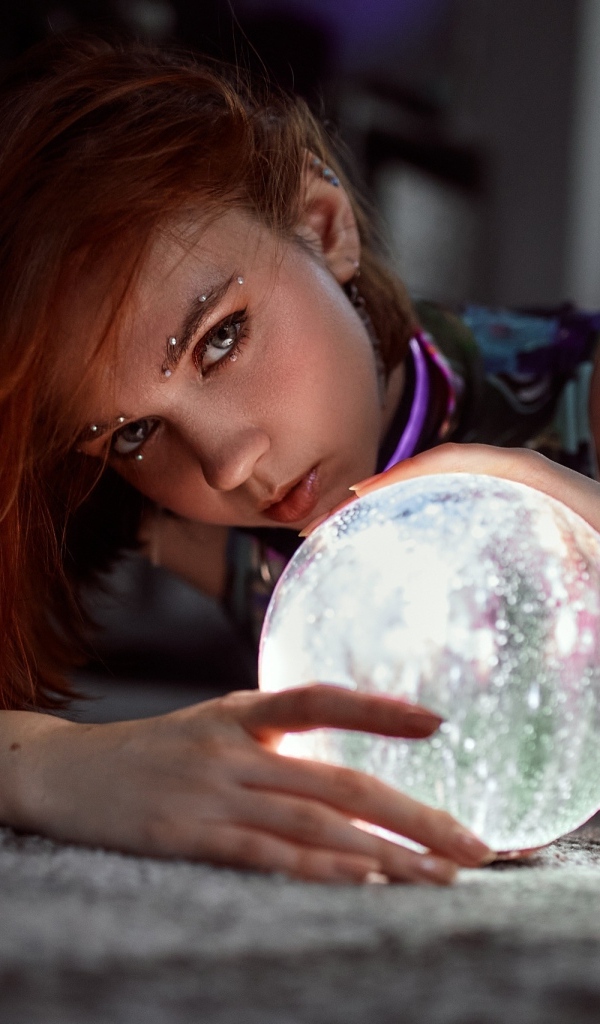 Девушка с пирсингом держит волшебный шар