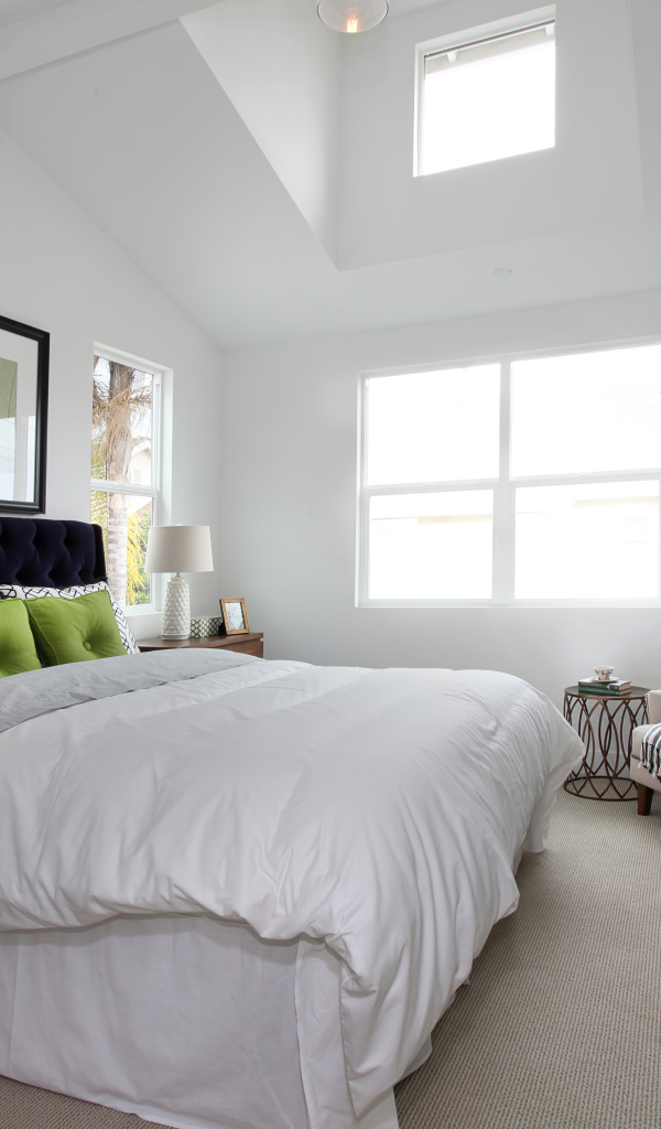 Высокая мягкая кровать в спальной комнате