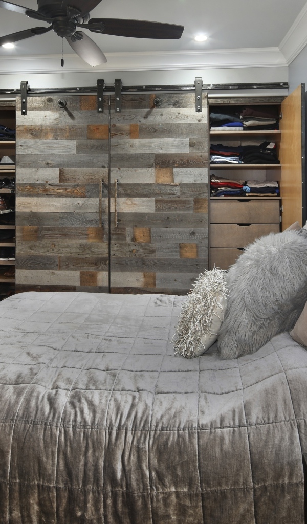 Большая мягкая кровать в спальне со шкафом