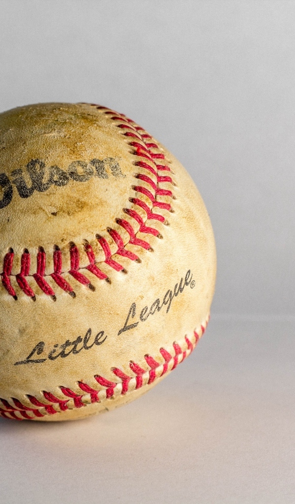 Старый бейсбольный мяч на сером фоне