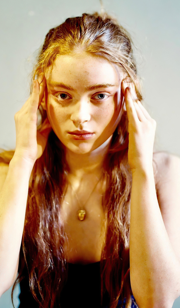 Рыжеволосая американская актриса Сэди Синк на сером фоне