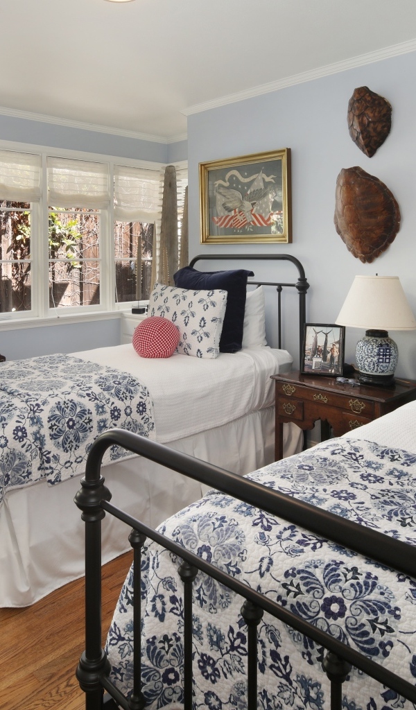 Две высокие кровати в спальной комнате