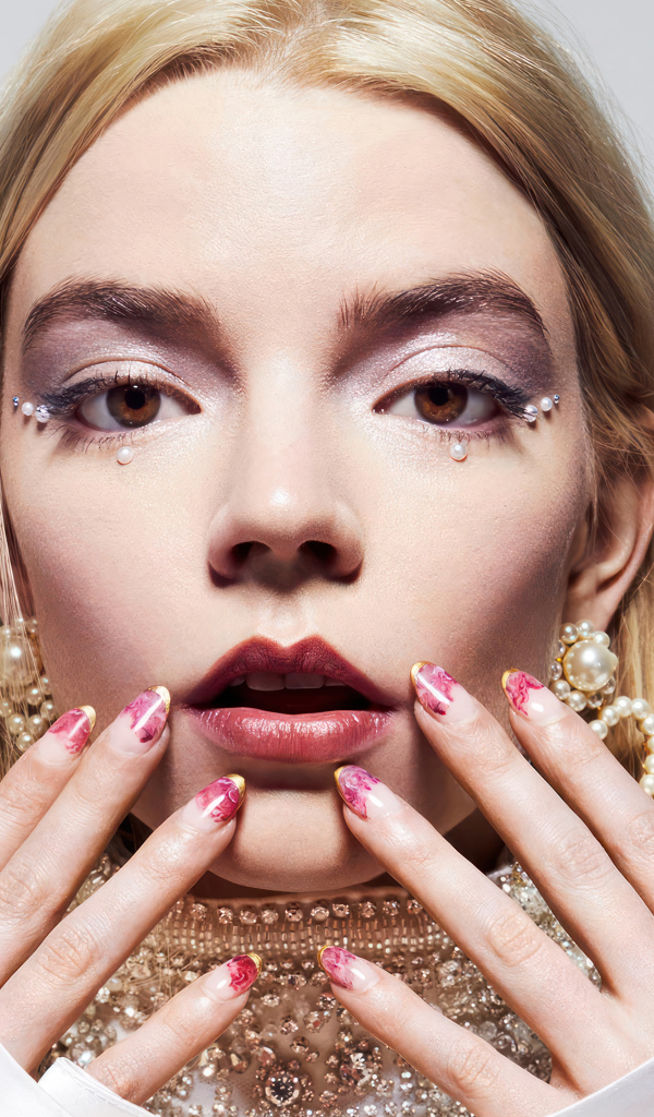 Молодая актриса Аня Тейлор-Джой с украшениями на сером фоне