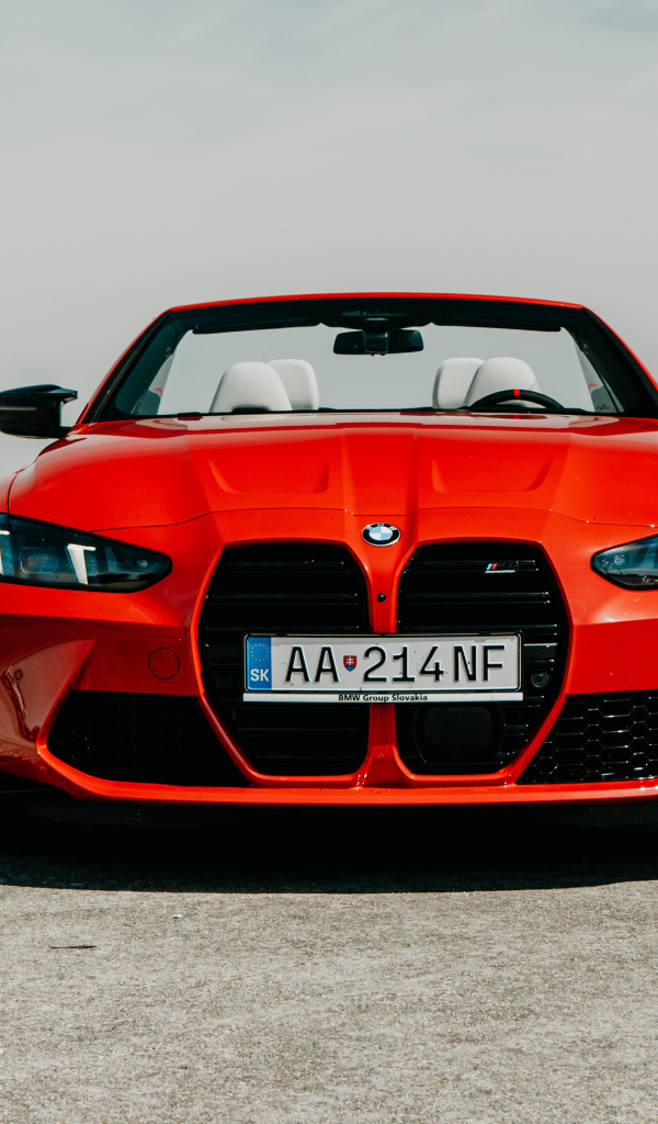 Вид спереди на красный автомобиль BMW M4 Competition M xDrive Cabrio 2024 года