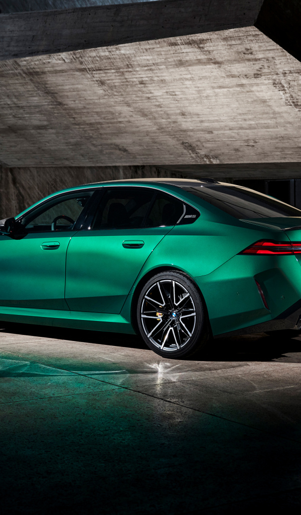 Вид сзади на зеленый автомобиль BMW M5 2024  года
