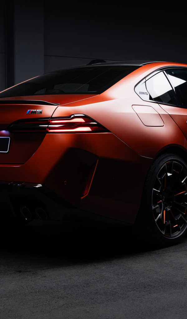 Вид сзади на красный автомобиль BMW M5 2025 года