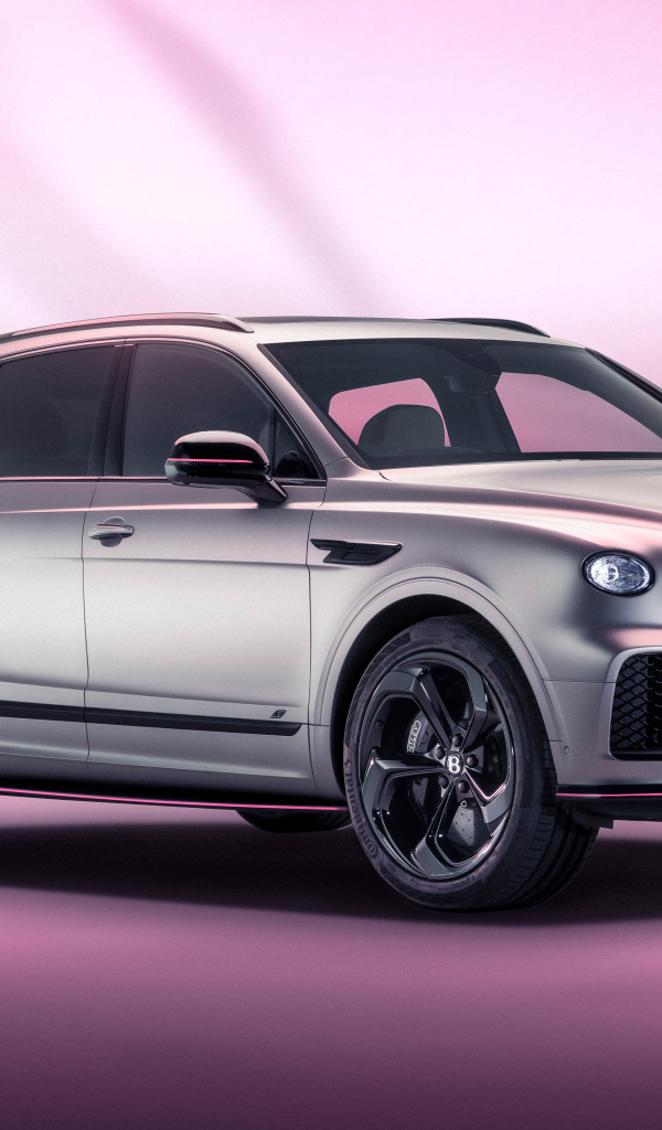 Серебристый автомобиль Bentley Bentayga V8 S Curated By Mulliner 2024 года на розовом фоне