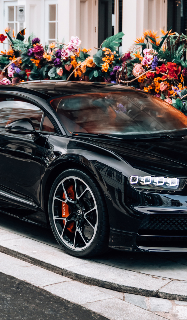 Черный автомобиль Bugatti Chiron у здания