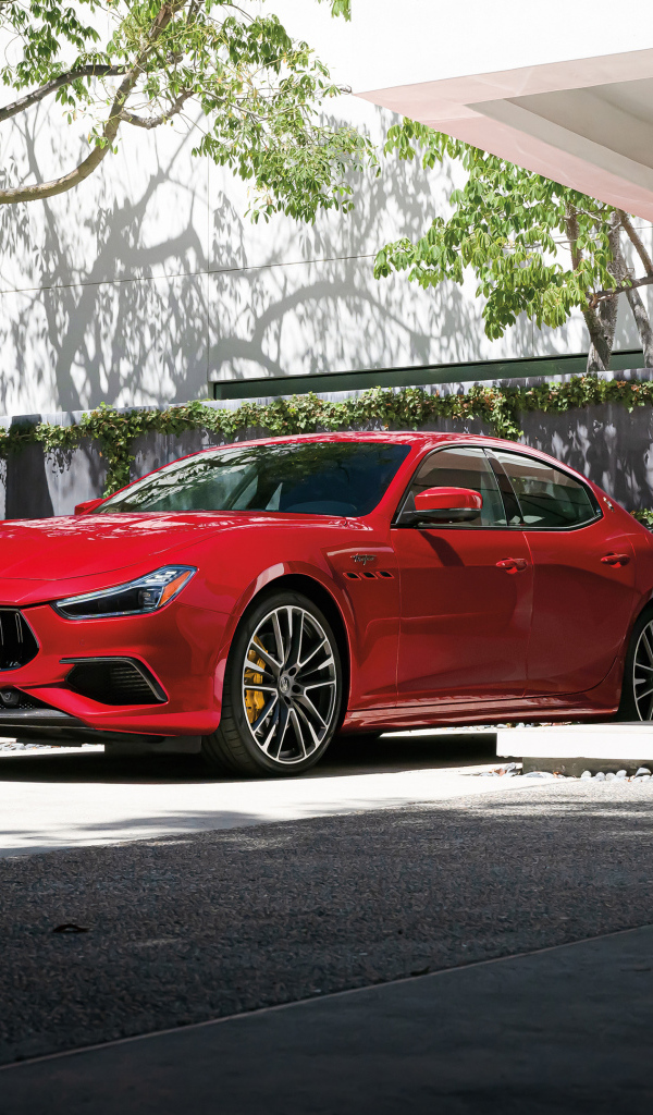 Красный автомобиль Maserati Ghibli Trofeo у дома