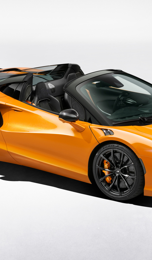 Оранжевый автомобиль McLaren Artura Spider на сером фоне