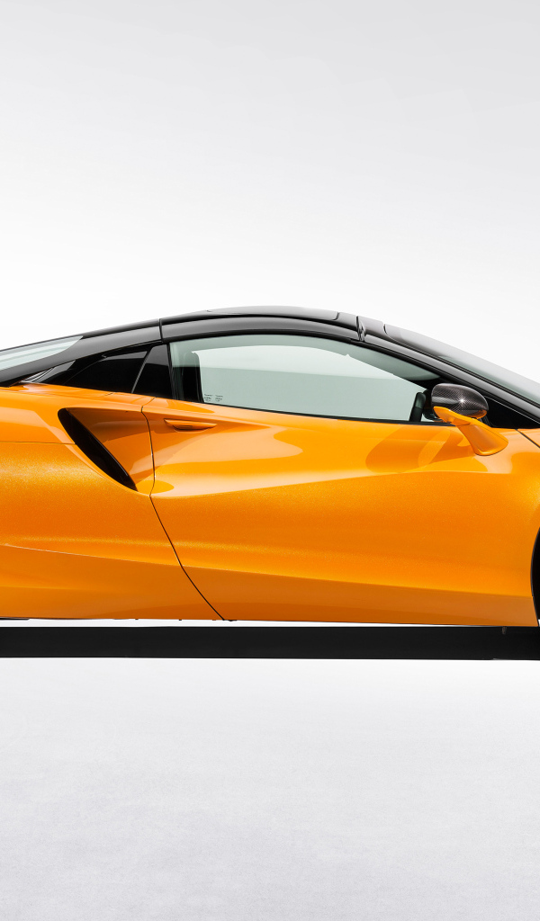 Вид сбоку на оранжевый автомобиль McLaren Artura Spider на белом фоне