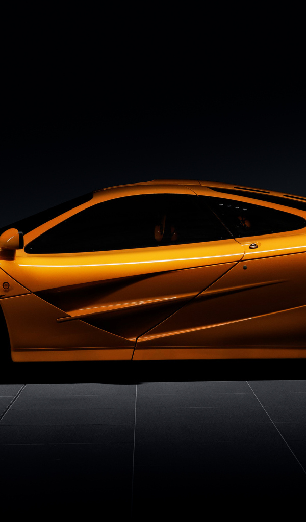 Вид сбоку на оранжевый автомобиль  McLaren F1 LM