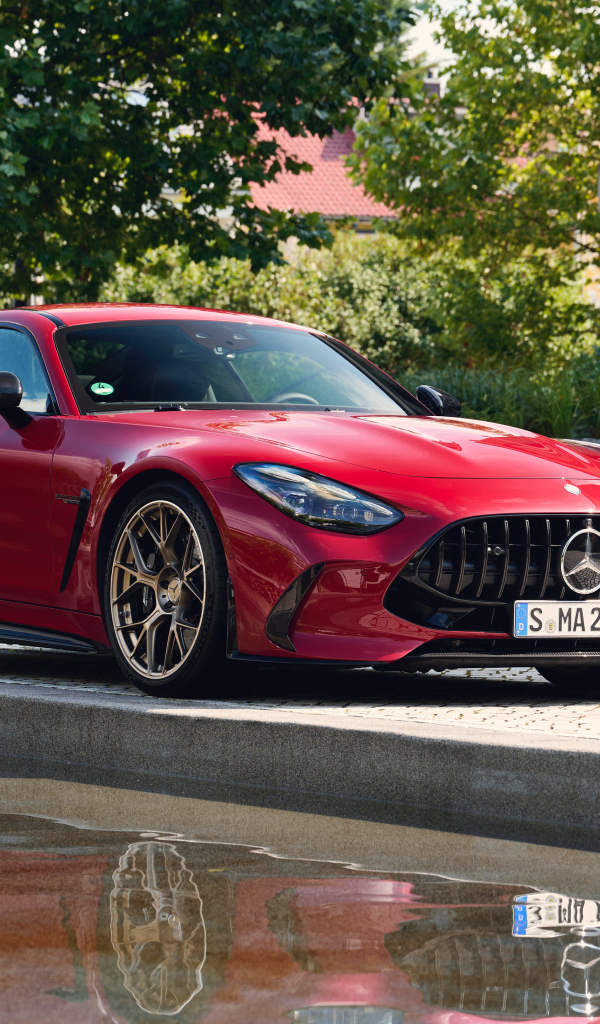 Красный автомобиль Mercedes-AMG GT 63 S E Performance 2024  года у воды