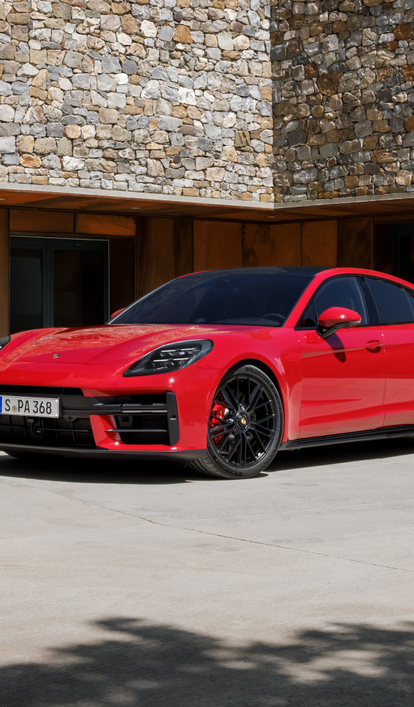 Красный автомобиль Porsche Panamera GTS 2024 года у здания