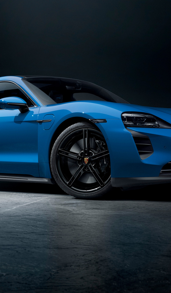 Синий автомобиль Porsche Taycan GTS на черном фоне