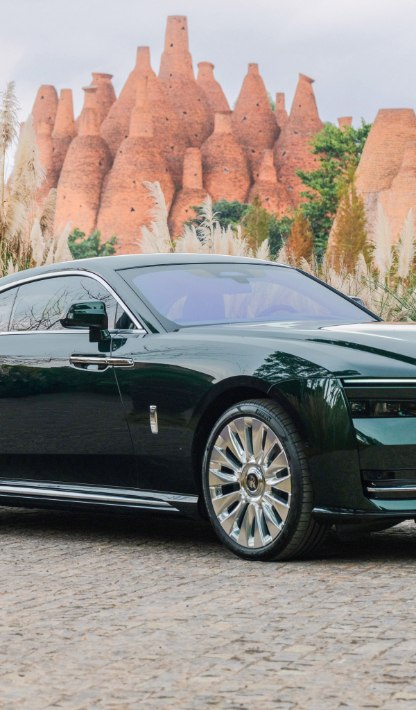 Дорогой зеленый автомобиль Rolls-Royce Spectre