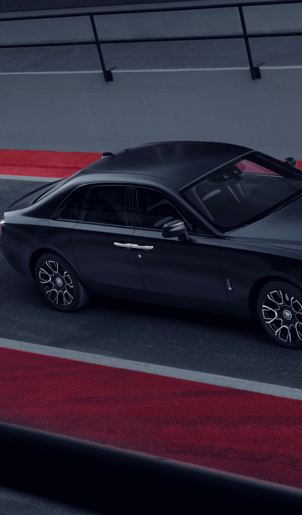 Черный автомобиль Rolls-Royce Black Badge Ghost на дороге