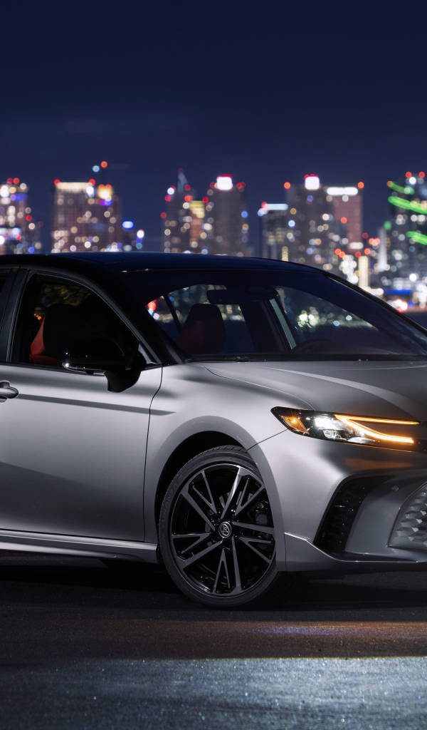 Новый автомобиль Toyota Camry XSE HEV AWD 2025 года на фоне города