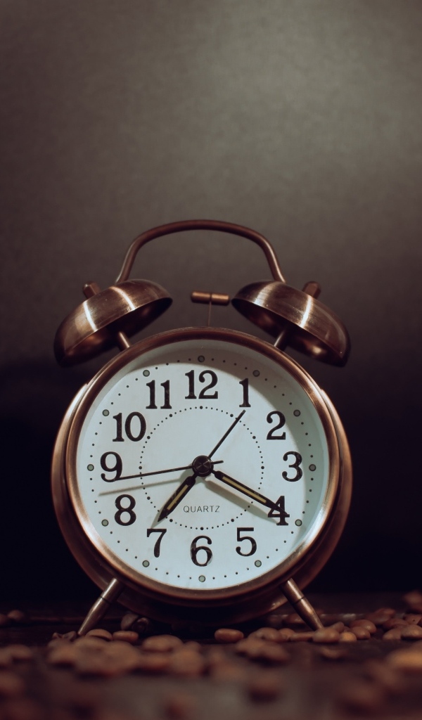 Будильник на столе с зернами кофе