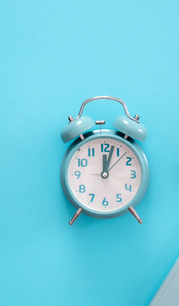 Будильник с книгами на голубом фоне