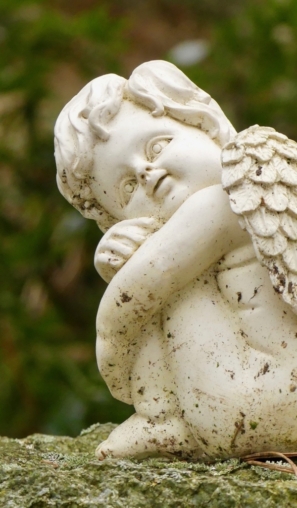 Статуэтка ангела стоит на камне