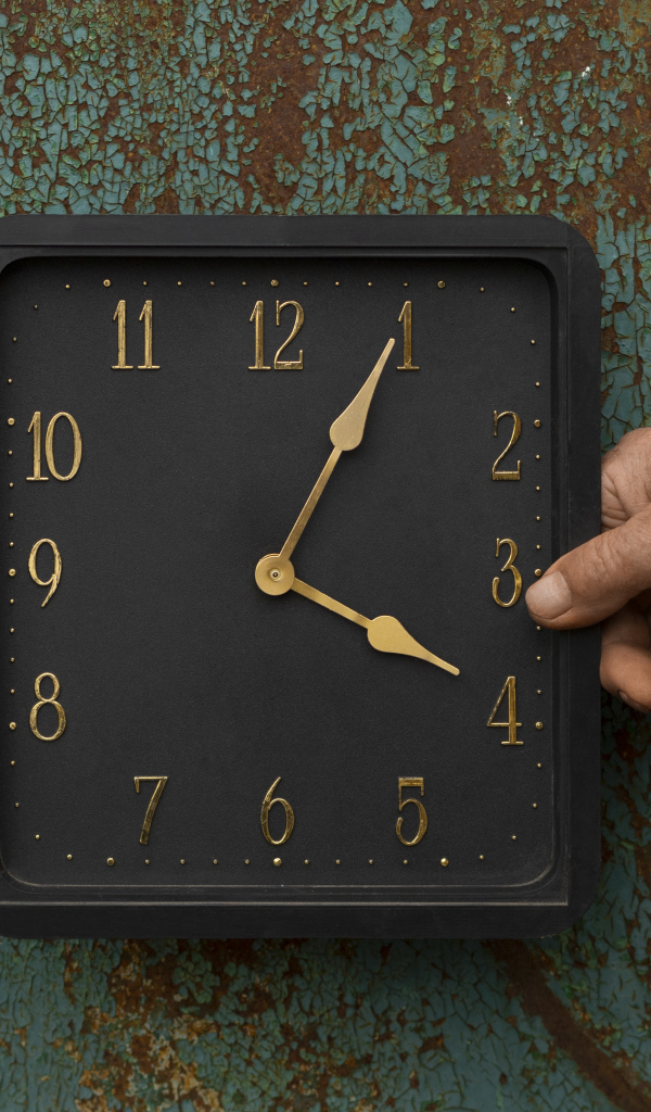 Черные квадратные часы на старой стене