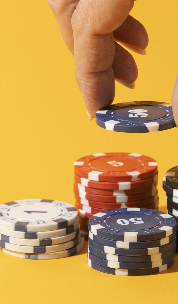 Фишки для казино с рукой на желтом фоне