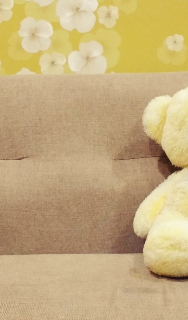 Милый игрушечный медведь на диване