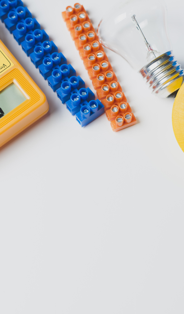 Электрическические приборы, мультиметр, изолента на сером фоне