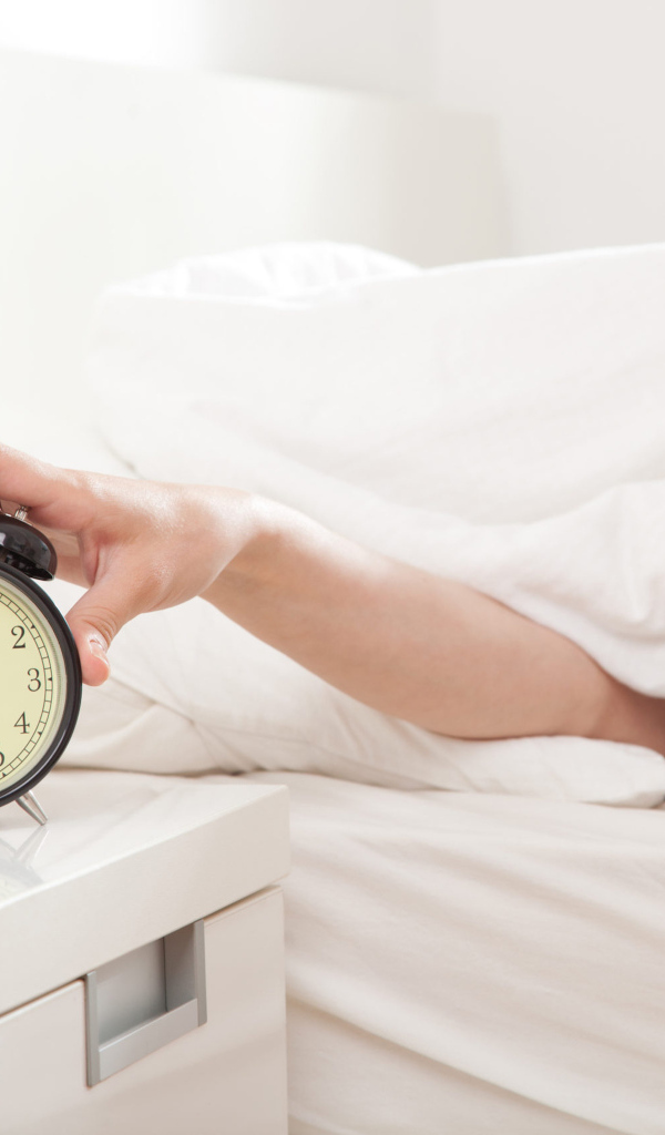 Рука под одеялом отключает будильник