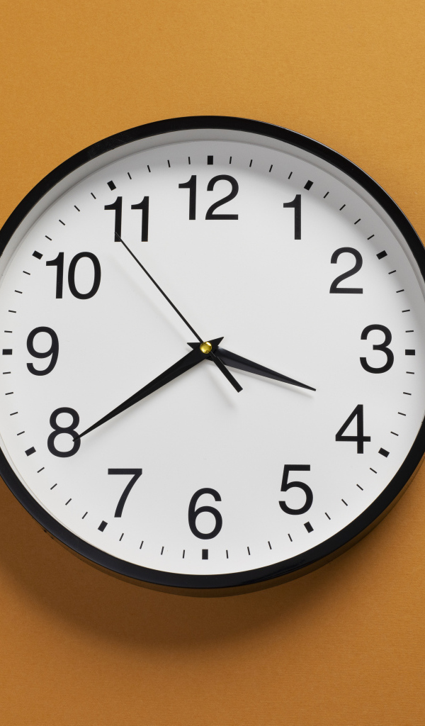 Большие круглые часы на желтом фоне