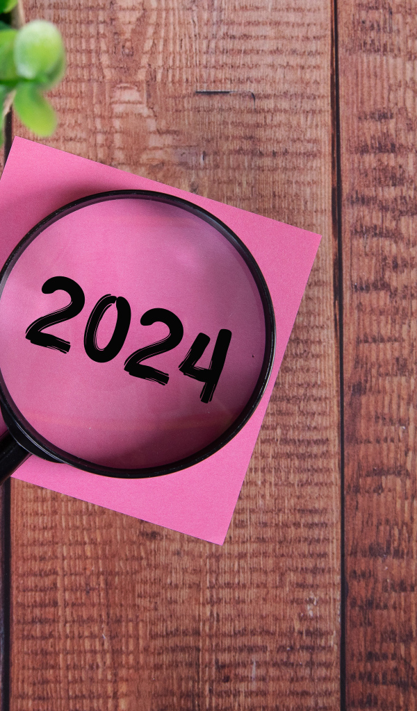 Увеличительное стекло с листом бумаги и цветком на столе