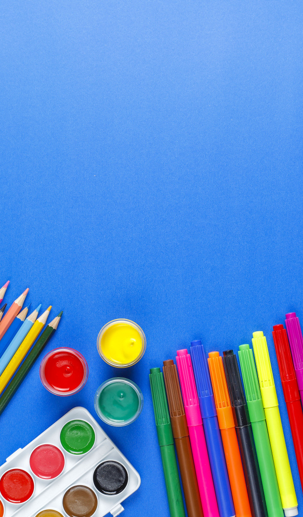 Карандаши, краски, фломастеры и кисти на голубом фоне