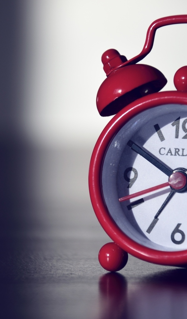 Красный будильник на черном столе